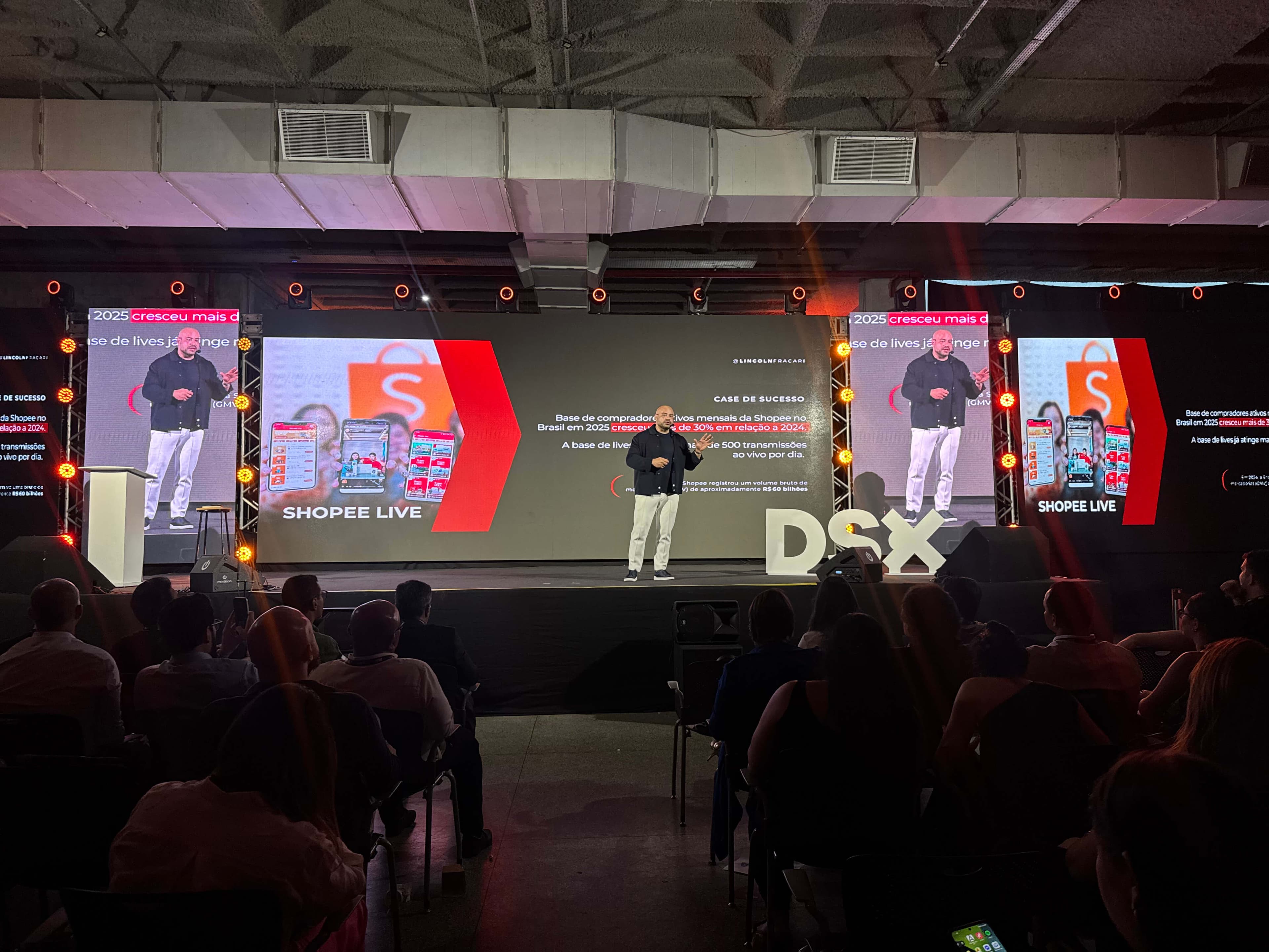 Apresentação de case no palco do DSX 2026, com o letreiro DSX ao lado